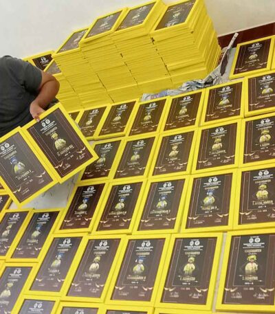 Professional worker showcasing a high-quality yellow graduation frame for bulk order.