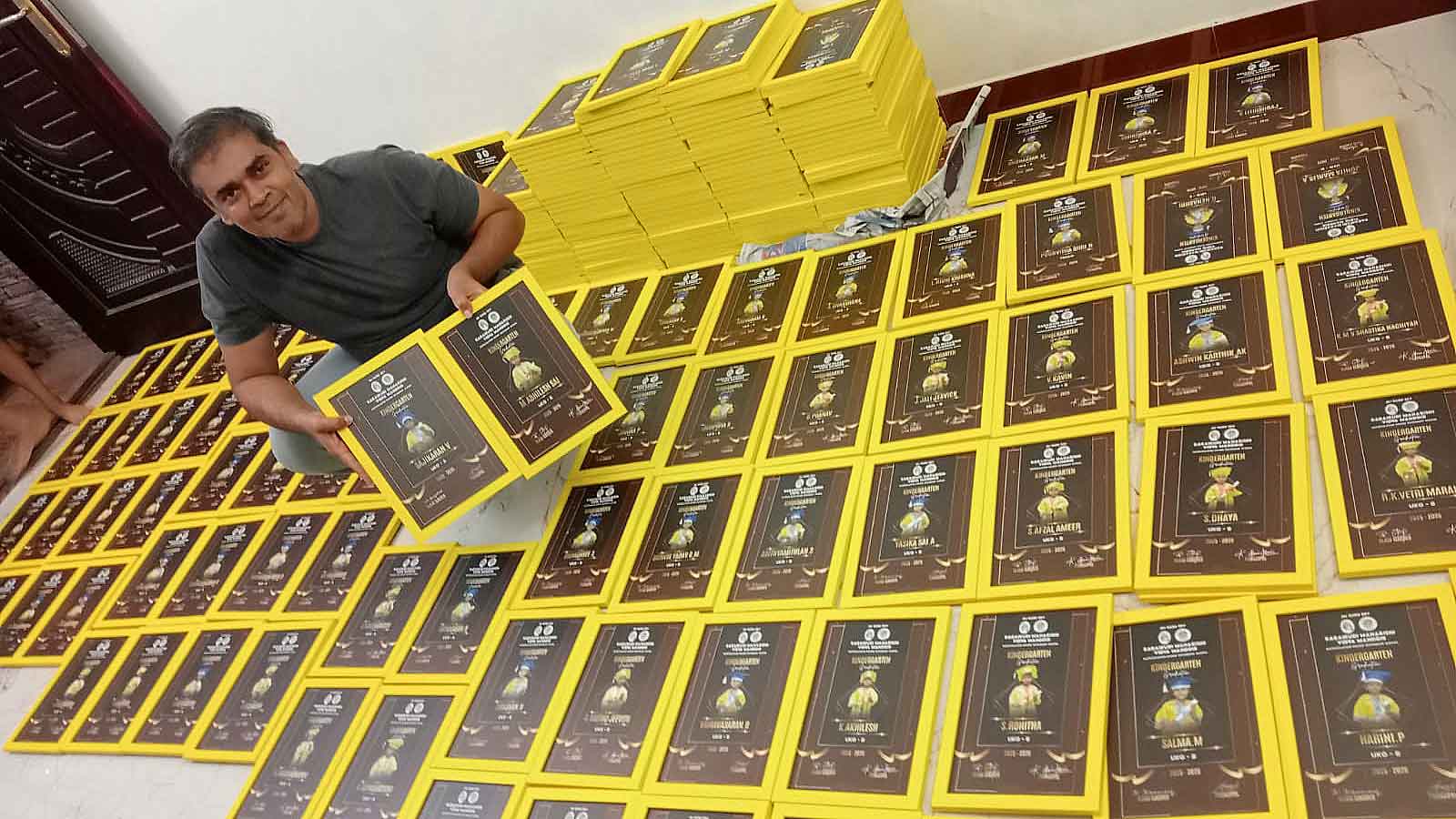 Professional worker showcasing a high-quality yellow graduation frame for bulk order.